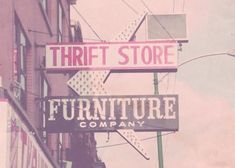 the sign for thrift store is pink and white, with an arrow pointing to the right