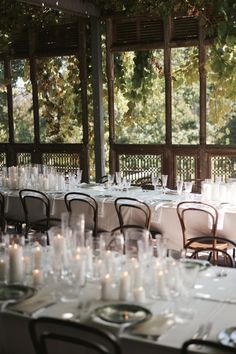 the tables are set up with candles and place settings for guests to sit down at