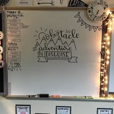 a whiteboard with some writing on it and lights around it that are hanging from the wall