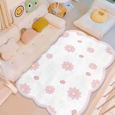 a baby's room with pink and white flowers on the rug