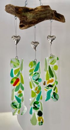 three pieces of art glass hanging from hooks