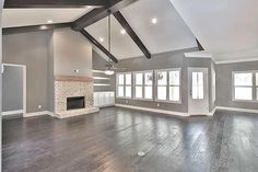 an empty living room with wood floors and gray walls, white trim on the ceiling