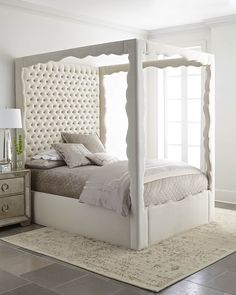 a white bed sitting on top of a carpet covered floor