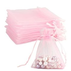 a bag filled with lots of pink and white pearls on top of a white background