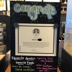 a sign that says congrats and drinks in front of a counter with other items on it