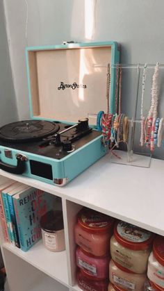 a record player sitting on top of a white shelf