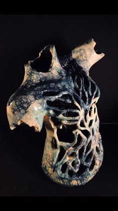 a ceramic horse head is shown on a black background with white and blue designs in the middle