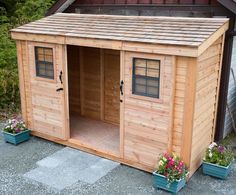 a small wooden shed with two doors and windows on the outside, surrounded by potted plants