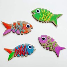 three fish made out of colored paper and string