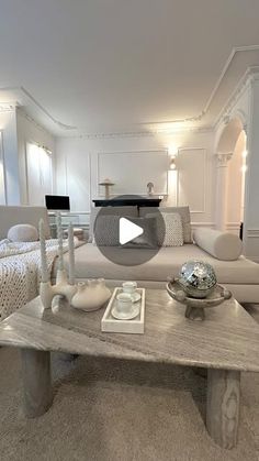 a living room filled with furniture and a table in front of a couches on top of carpeted flooring