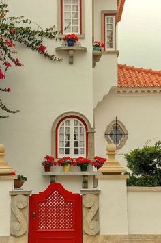 a red door is in front of a white building