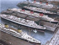 three large ships are docked in the water next to each other and one is white