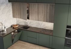 a kitchen with green cabinets and wooden flooring is pictured in this image, there is a sink on the counter next to the stove