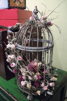 a bird in a cage with flowers on it