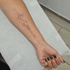 a woman's arm with a sun and moon tattoo on the left side of her hand