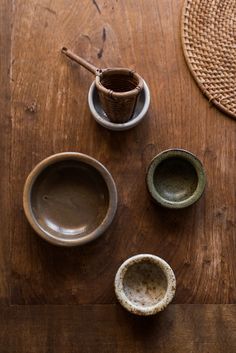 three bowls and two spoons on a wooden table