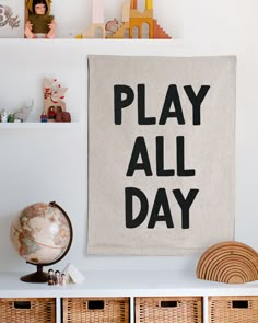 there is a play all day sign on the wall next to some baskets and toys