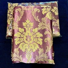 a purple and gold damask cloth on a blue surface