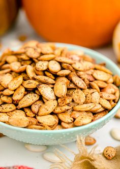 a bowl filled with nuts sitting on top of a table next to other pumpkins