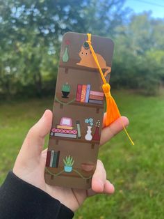 a person holding up a phone case with an image of a book shelf on it