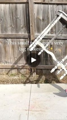 a person standing in front of a wooden fence with an upside down skateboard on it