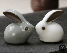 two ceramic rabbits sitting next to each other