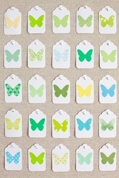 small butterfly shaped tags with different colors and patterns on the top one is green, yellow, blue, white, and pink