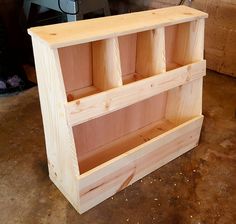 a wooden shelf with three compartments on the bottom and one section open to show what's inside