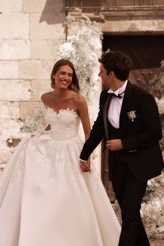 the bride and groom are walking hand in hand