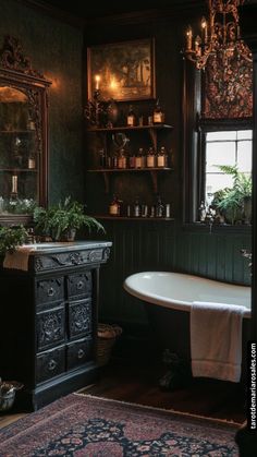 an old fashioned bathtub and sink in a room with dark green walls, wood trimming