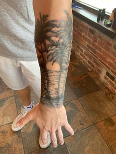 a man with a palm tree tattoo on his arm