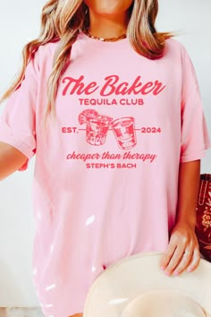 a woman wearing a pink shirt with the baker tequila club on it's chest