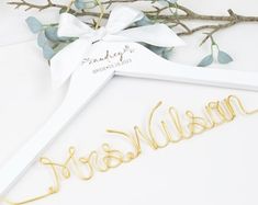 a wedding dress hanger with the word bride and groom on it next to some branches