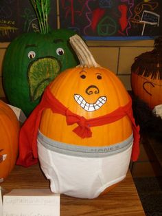 three pumpkins with faces painted on them sitting on a table next to each other