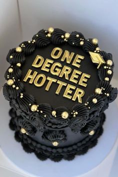 a black and gold decorated cake with the words one degree potter on it's side