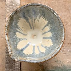 a white and blue bowl sitting on top of a wooden table