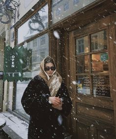 a woman standing in front of a store with snow falling all over her and the words thank you