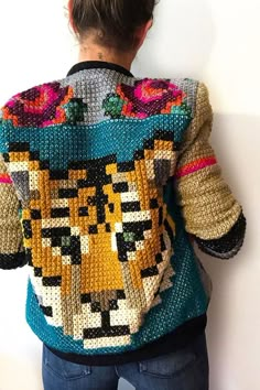 a woman is wearing a colorful sweater with an animal design on it and has her back turned to the camera