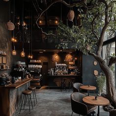 the interior of a restaurant with wooden tables and stools next to a large tree