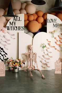 there is a skeleton sitting on the table in front of some fake flowers and eggs