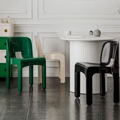 two chairs sitting next to each other in front of a white table and chair set