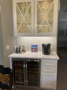 a kitchen with white cabinets and glass doors