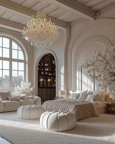 an elegant bedroom with white furniture and chandelier above the bed in front of large windows