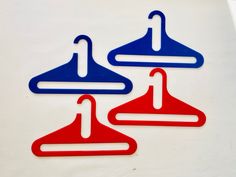 three red, white and blue hangers are on a white surface with a black background