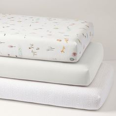 three sheets stacked on top of each other in different patterns and sizes, one is white