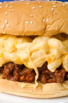 a cheeseburger with macaroni and cheese is on a plate, ready to be eaten