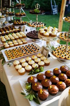 a table topped with lots of cupcakes and cakes