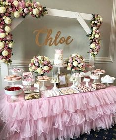 a table topped with lots of pink and white desserts