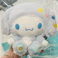 a hand holding a small stuffed animal with stars on it's head and eyes