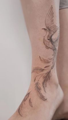 a woman's leg with a bird tattoo on it